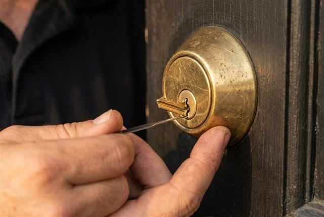 Close-up of a locksmith using an extractor tool to remove a snapped key from a deadbolt in San Diego